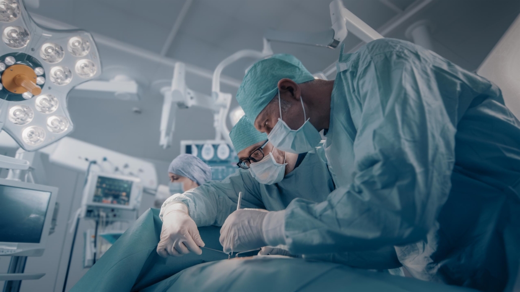 Diverse Team of Professional surgeon, Assistants and Nurses Performing Invasive Surgery on a Patient in the Hospital Operating Room